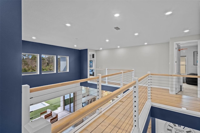 hallway featuring recessed lighting, visible vents, and an upstairs landing