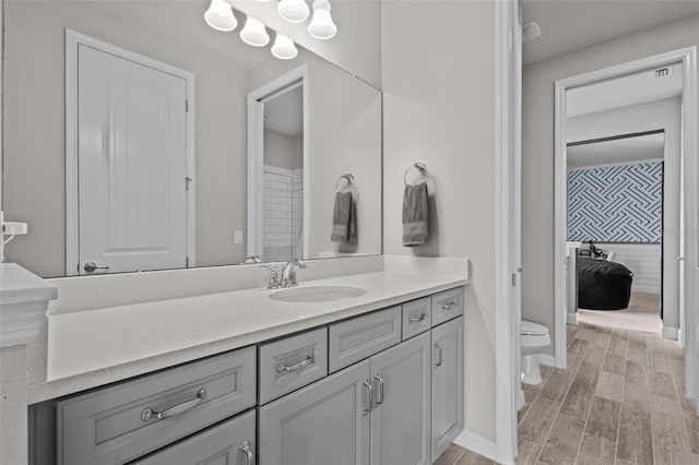 full bath with wood tiled floor, baseboards, vanity, and toilet