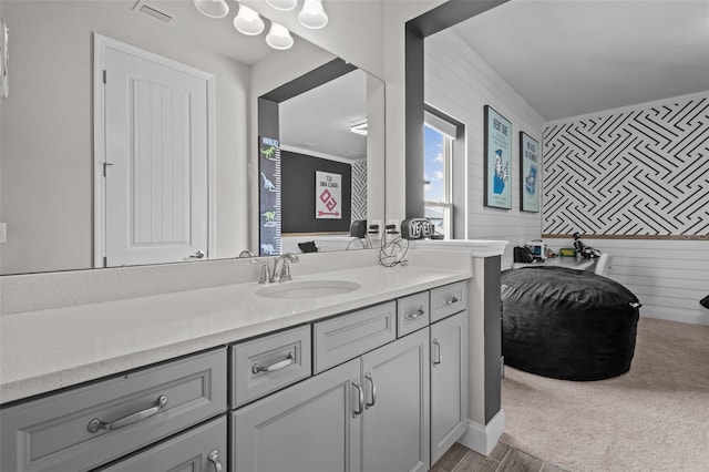 bathroom featuring vanity, visible vents, and wooden walls