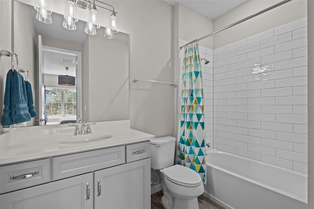 full bath with toilet, shower / bath combo with shower curtain, and vanity