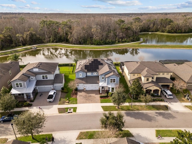 drone / aerial view with a water view, a forest view, and a residential view