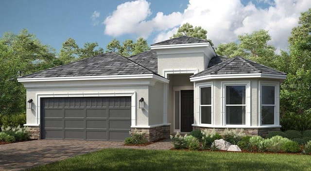 view of front of house with decorative driveway, stone siding, an attached garage, and stucco siding