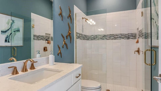 bathroom with toilet, a shower stall, and vanity