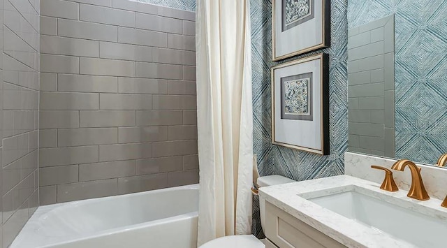 full bath with shower / bath combination with curtain, vanity, toilet, and wallpapered walls