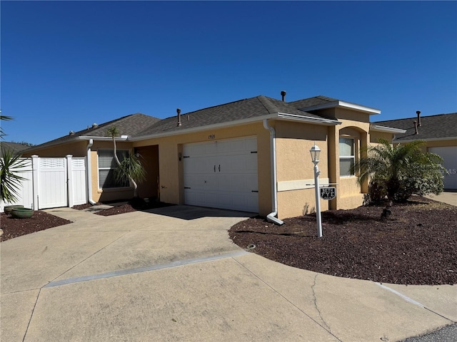 ranch-style house with a garage, fence, concrete driveway, roof with shingles, and stucco siding