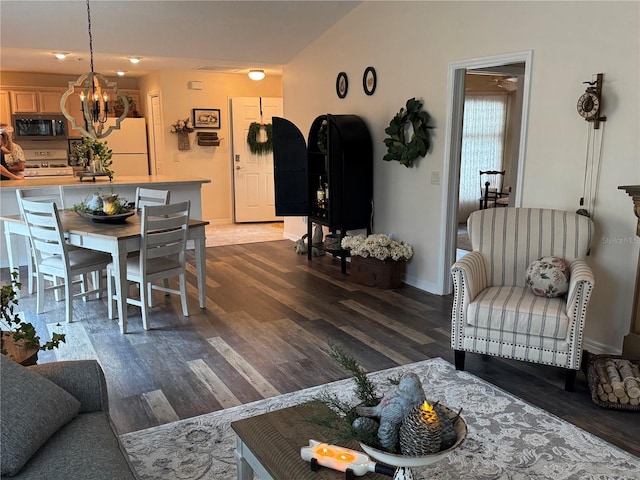 living area with baseboards, a chandelier, and dark wood-style flooring