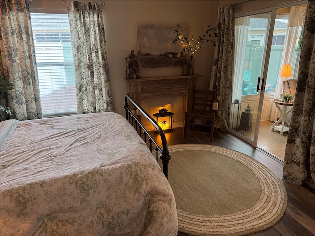 bedroom with a fireplace and dark wood finished floors