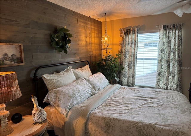 bedroom with wood walls and a textured ceiling