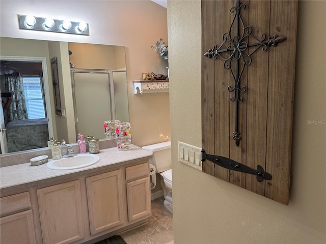 bathroom with toilet, a shower stall, and vanity