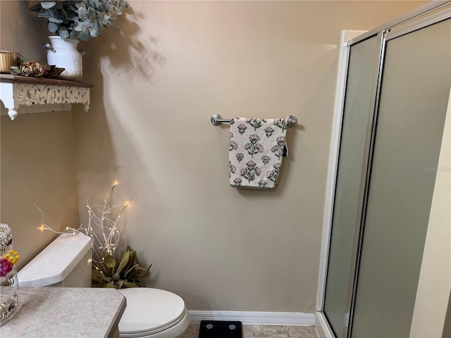 bathroom featuring a stall shower, baseboards, vanity, and toilet