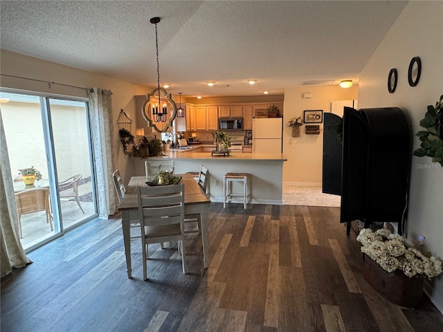 dining area with an inviting chandelier, baseboards, dark wood finished floors, and a textured ceiling