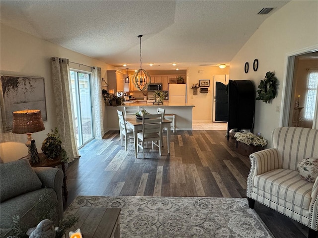 dining area with visible vents, a textured ceiling, and wood finished floors