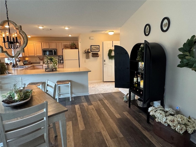 interior space with a chandelier, dark wood finished floors, and baseboards