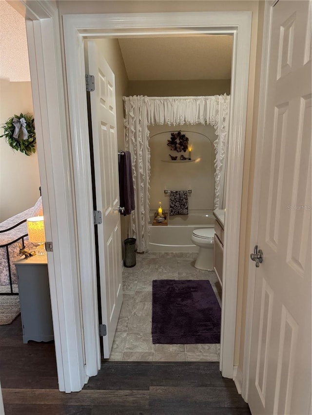 bathroom with toilet, tile patterned floors, shower / bathtub combination with curtain, and vanity