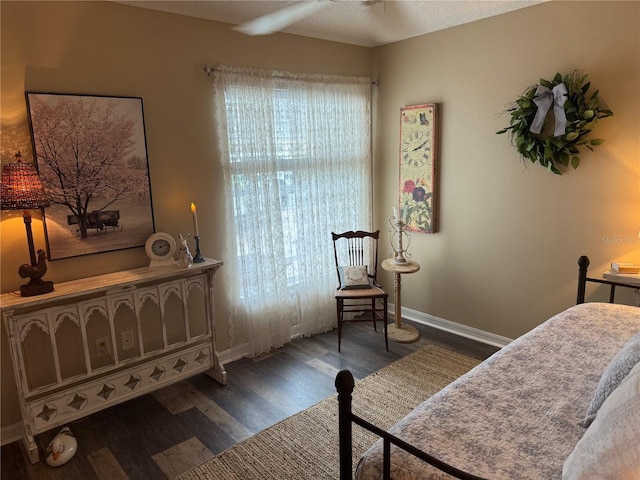 bedroom with dark wood-style flooring and baseboards