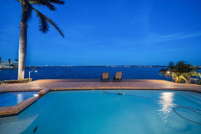 view of swimming pool featuring a water view and a pool with connected hot tub