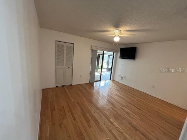 unfurnished bedroom featuring light wood-style floors, ceiling fan, and a textured ceiling