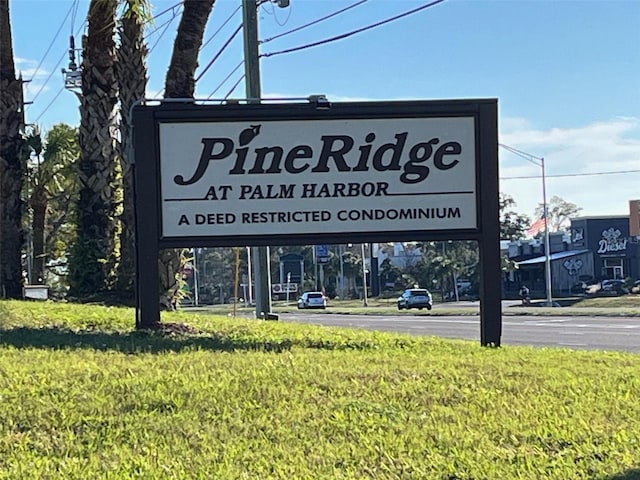 community / neighborhood sign featuring a yard