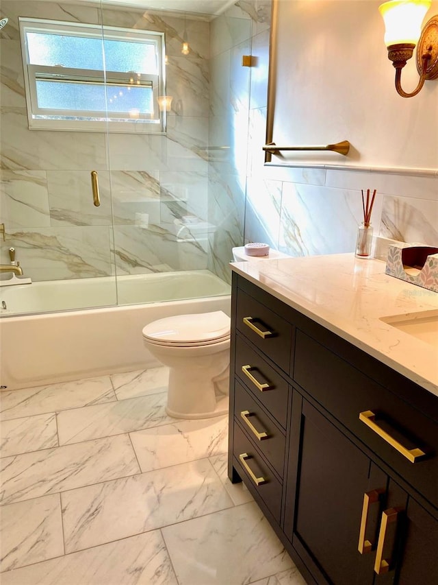 bathroom with marble finish floor, shower / bath combination with glass door, vanity, and toilet