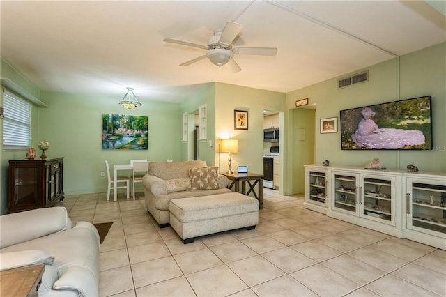 living area with ceiling fan, visible vents, and light tile patterned flooring