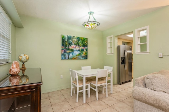 dining space featuring light tile patterned floors and baseboards