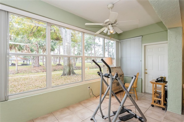 exercise area with light tile patterned flooring and a ceiling fan