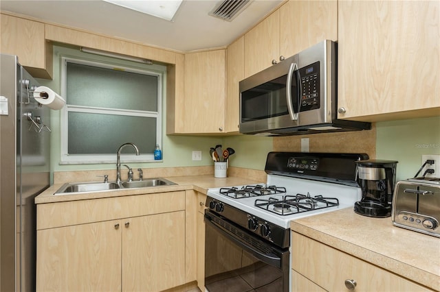 kitchen featuring light brown cabinetry and appliances with stainless steel finishes