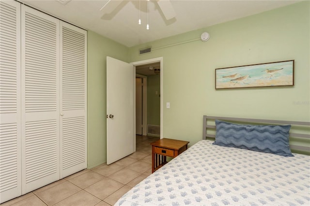 bedroom with light tile patterned floors, a ceiling fan, visible vents, and a closet