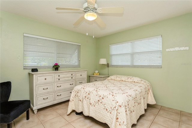 bedroom featuring light tile patterned floors, baseboards, and a ceiling fan