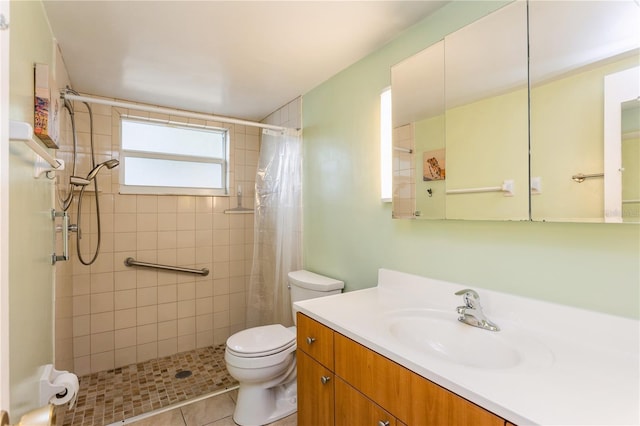 bathroom with vanity, a tile shower, and toilet