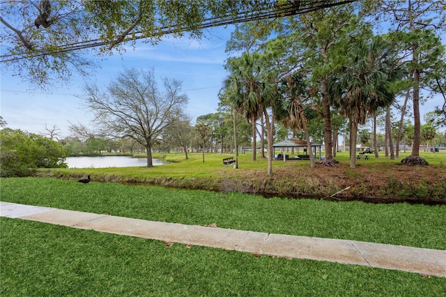 surrounding community with a gazebo, a lawn, and a water view