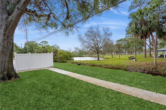 view of yard with a water view and fence