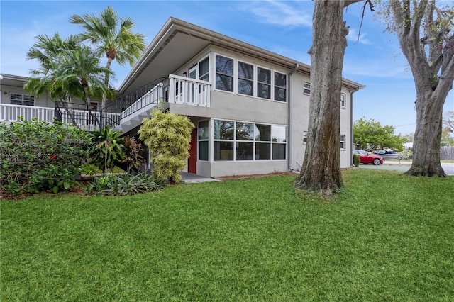 back of property featuring a yard and stucco siding