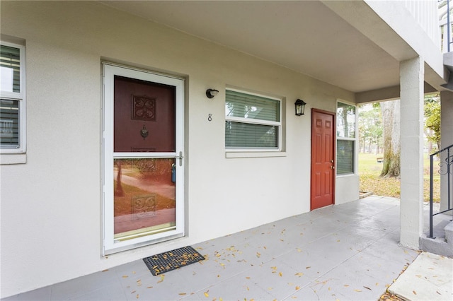 doorway to property featuring stucco siding