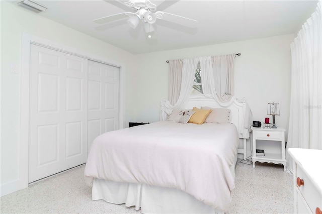 bedroom featuring a ceiling fan, light speckled floor, visible vents, and a closet