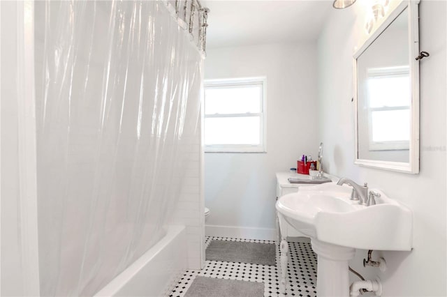 full bath featuring tile patterned flooring, a sink, baseboards, toilet, and shower / bathtub combination with curtain