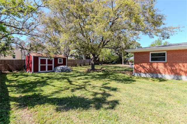 view of yard with an outbuilding, a shed, and fence private yard