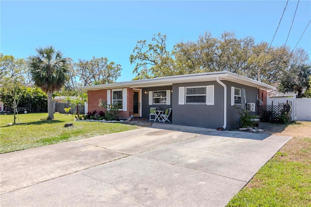 ranch-style house with a front yard, fence, brick siding, and stucco siding