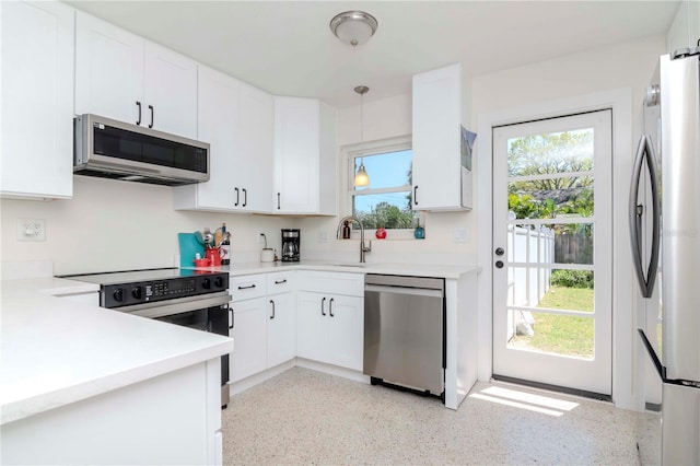 kitchen with white cabinetry, light countertops, a healthy amount of sunlight, and stainless steel appliances