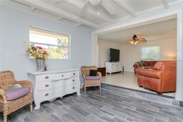 sitting room featuring a ceiling fan, beam ceiling, and a healthy amount of sunlight