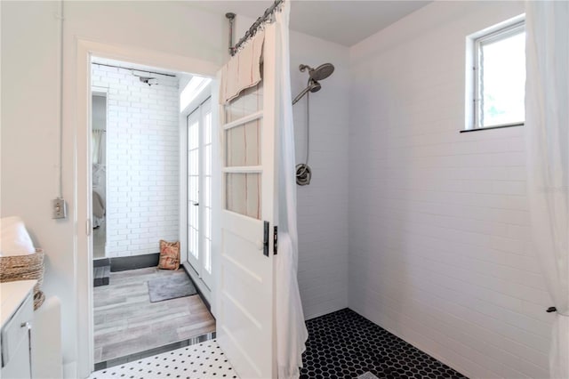 bathroom featuring vanity, wood finished floors, and a tile shower