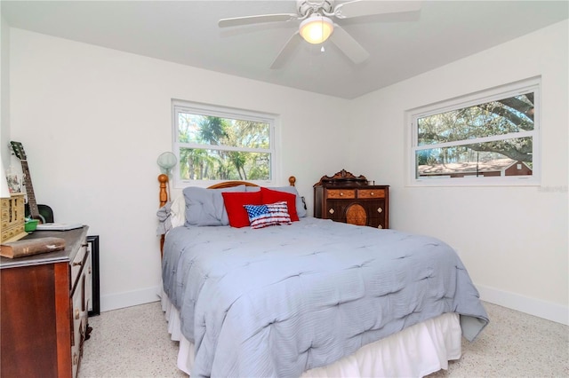 bedroom featuring ceiling fan, light speckled floor, and baseboards