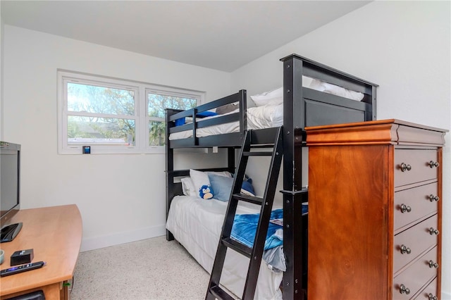 bedroom featuring speckled floor and baseboards