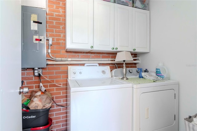 laundry room with electric panel, washer and dryer, and cabinet space