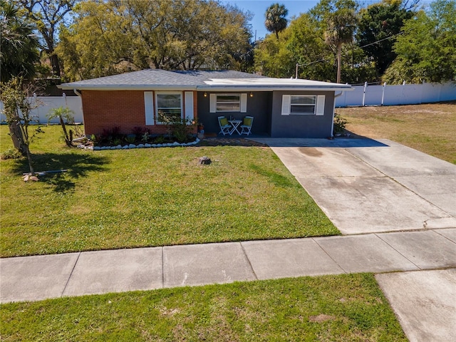 ranch-style home featuring brick siding, a front lawn, and fence