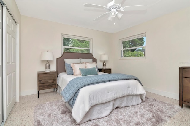 bedroom with ceiling fan, baseboards, a closet, and speckled floor