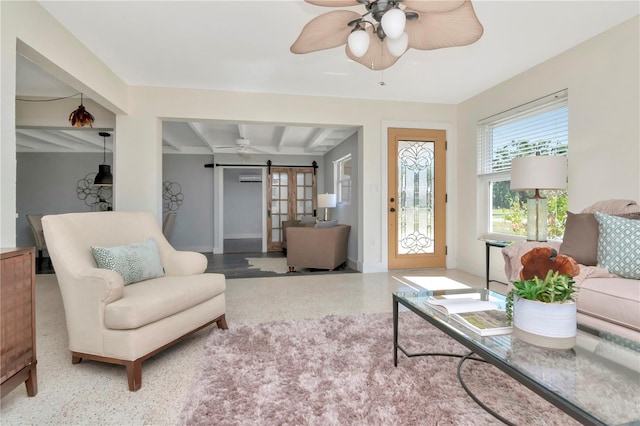 living room with baseboards, ceiling fan, a barn door, and speckled floor