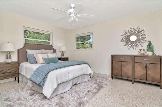 bedroom featuring baseboards, a ceiling fan, and speckled floor