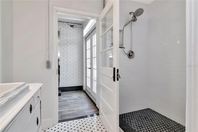 full bathroom featuring a tile shower and vanity