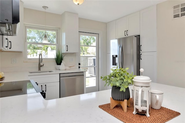 kitchen featuring light countertops, appliances with stainless steel finishes, visible vents, and a sink